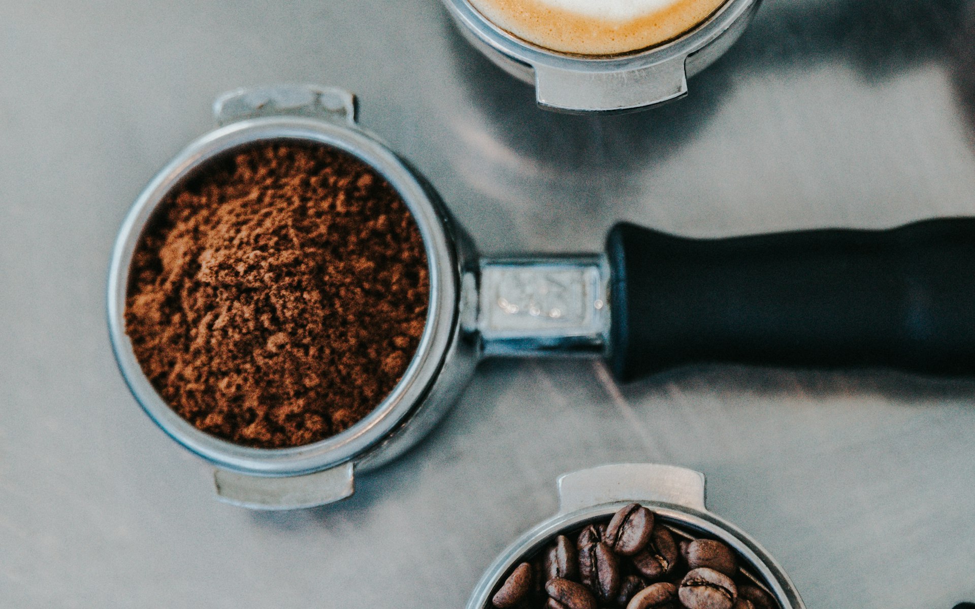 Portafilter and fresh grounds on a metal counter